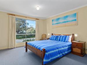 a bedroom with a bed and a large window at 22 Broadbeach Drive in Normanville