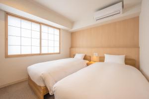 Postel nebo postele na pokoji v ubytování Fuji Hotel Kyoto Gojo