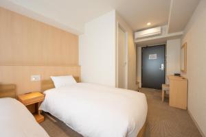 Postel nebo postele na pokoji v ubytování Fuji Hotel Kyoto Gojo