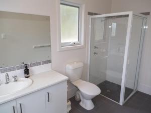a bathroom with a toilet and a sink and a shower at Shearers Rest 5 Davey Road in Normanville +13 photos