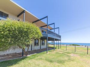 a house on the beach with the ocean in the background at Sandy Feet 31 Gold Coast Drive in Normanville
