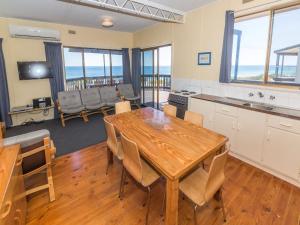 a kitchen and dining room with a table and chairs at Sandy Feet 31 Gold Coast Drive in Normanville