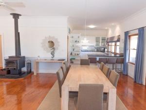 a dining room and kitchen with a table and a stove at 3 Banksia Court in Normanville