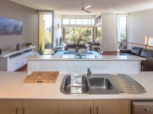 a kitchen with a sink and a living room at South Shores Villa 52 in Normanville