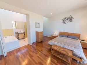 une chambre avec un lit et une baignoire dans l'établissement South Shores Villa 52, à Normanville 17 autres photos