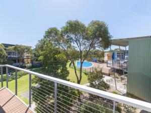un balcon d'appartement avec vue sur une piscine dans l'établissement South Shores Villa 52, à Normanville
