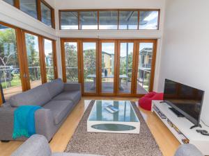 a living room with a couch and a tv at South Shores Villa 50 in Normanville