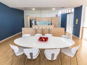 a white table with white chairs and a kitchen at South Shores Villa 50 in Normanville