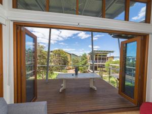 a room with a table on a balcony with glass doors at South Shores Villa 50 in Normanville