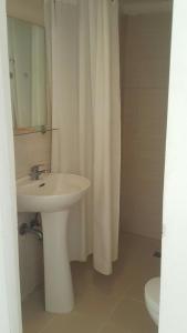 a bathroom with a sink and a white shower curtain at Islands Stay Hotels Mactan in Mactan +19 photos