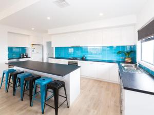 諾曼威爾的住宿－21 30 Troon Drive，厨房配有黑色柜台和蓝色瓷砖