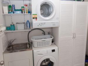 a small kitchen with a washing machine and a sink at 12 Lady Bay in Normanville