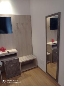 Spiegelreflexion eines Zimmers mit einem Schreibtisch und einem Spiegel in der Unterkunft Ke Rooms in Campomarino