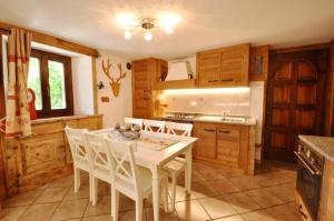 cocina con mesa blanca y sillas blancas en Bilocale montano, en La Thuile