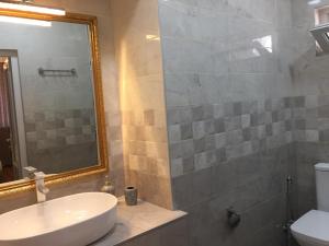 a bathroom with a sink and a mirror and a toilet at HOTEL COMFORT in Kutaisi