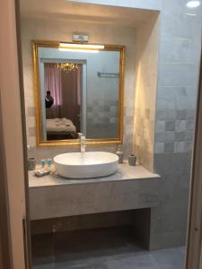 a bathroom with a sink and a mirror at HOTEL COMFORT in Kutaisi