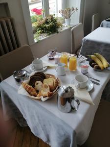 プロンビエール・レ・バンにあるAcacias Apparts Hotelのクロワッサンとオレンジジュースの朝食付きのテーブル