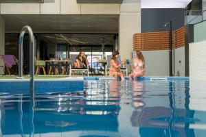 two girls are playing in a swimming pool at Hyperion City Hotel & Spa in Chania