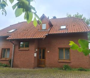 a red brick house with a red roof at Schickebude-Steinhude-1-400m-zum-naechsten-oeffentlichen-Wasserzugang-5-Minuten-zur-Badeinsel-ruhige-Lage-mit-schoenem-Aussenbereich in Steinhude