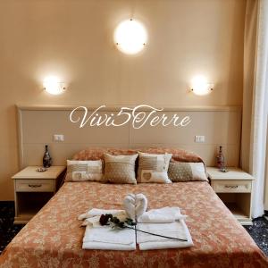 een bed met handdoeken en een bord dat uw ware bij Vivi 5 terre in La Spezia
