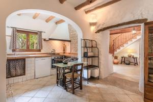 a kitchen with an archway and a table in a room at Finca Son Palanca in Sineu
