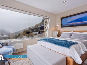 ein Schlafzimmer mit einem Bett und einem großen Fenster in der Unterkunft The Peak 7 in Thredbo