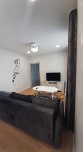 sala de estar con sofá y mesa en Jaukūs apartamentai centre, en Šiauliai