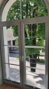 a window with a view of a tree outside at Jaukūs apartamentai centre in Šiauliai