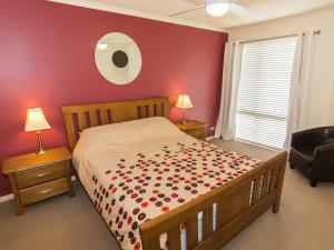 a bedroom with a large bed with red walls at 37 Oceanview Drive in Second Valley