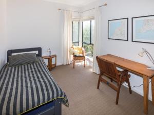 a bedroom with a bed and a desk and a desk at 20 Lady Bay Road in Normanville