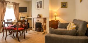 a living room with a couch a table and a fireplace at Millbrae Townhouse in Buncrana