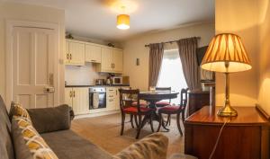a kitchen and a living room with a table and chairs at Millbrae Townhouse in Buncrana