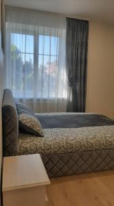 a bedroom with a bed with a window and a table at Jaukūs apartamentai centre in Šiauliai