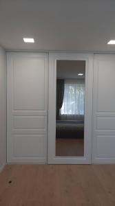 um quarto com duas portas de correr com uma janela em Jaukūs apartamentai centre em Siauliai