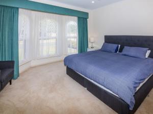 ノーマンビルにあるBeachside at Normanville 7 Ronald Streetの青いベッドと2つの窓がある寝室