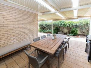 ノーマンビルにあるBeachside at Normanville 7 Ronald Streetのパティオにある木製のテーブルと椅子