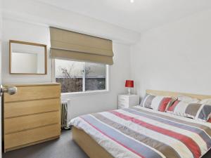sypialnia z łóżkiem z komodą i oknem w obiekcie Beach Fun 11 Broadbeach Drive w mieście Carrickalinga