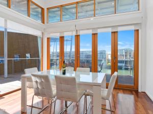 a dining room with a white table and white chairs at South Shores Villa 59 in Normanville