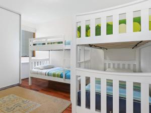 two bunk beds in a room with a mirror at South Shores Villa 59 in Normanville