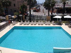 薩洛的住宿－普拉納斯酒店，一个带椅子和遮阳伞的大型蓝色游泳池