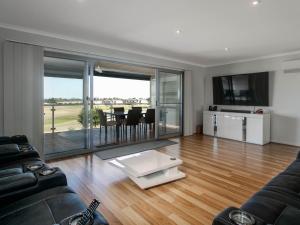 a living room with a couch and a table at 52 Turnberry Drive in Normanville