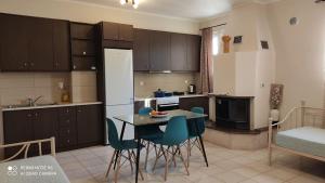 a kitchen with a table and chairs in a room at Kalliope Apartments in Tsoukalades