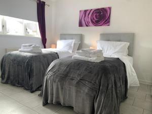 two beds in a room with towels on them at Dada Apartment in Glasgow