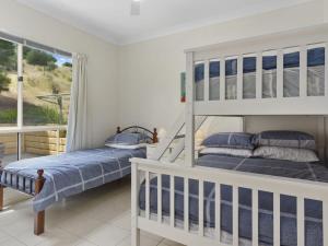 sypialnia z 2 łóżkami piętrowymi i balkonem w obiekcie Carrickalinga Dreams 15 Solitude Drive w mieście Carrickalinga
