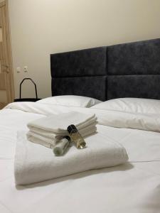 - une pile de serviettes et d'une bouteille sur le lit dans l'établissement V15 Apartment, à Druskininkai