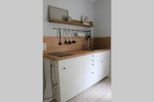 a kitchen with white cabinets and a sink at FeWo Zum Schloss in Weißenfels