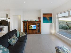 a living room with a couch and a large window at Fleurieu Coastal Retreat Lot 150 Myponga Beach in Wattle Flat