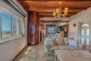 a living room with a couch and a table at Carmine Olive Villa in Agia Pelagia