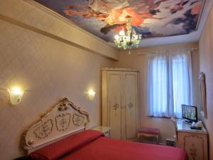 a bedroom with a bed with a painting on the ceiling at Hotel Diana in Venice +69 photos