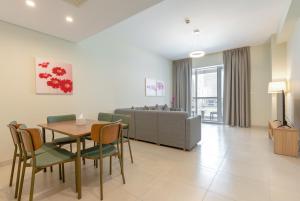 ein Wohnzimmer mit einem Tisch, Stühlen und einem Sofa in der Unterkunft Grand Stay Holiday Homes Rental in Dubai